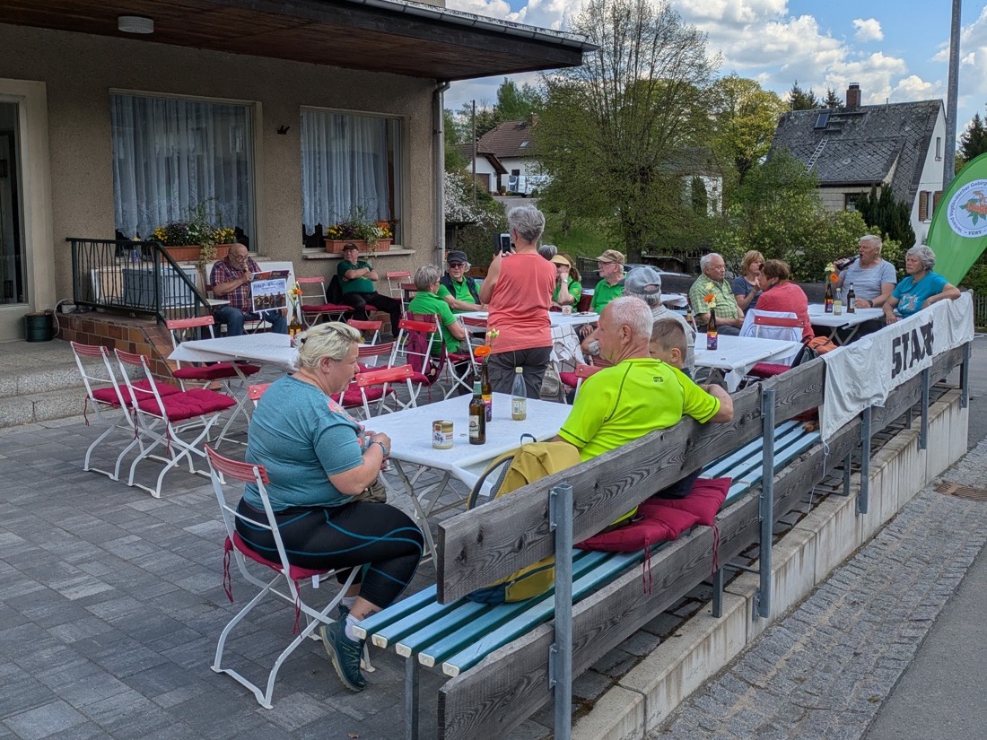 Wanderer an Tischen auf der Terrasse am Konsum, heute